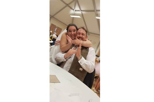 Caroline Setford, manager at Bedhampton Community Centre, has been teaching short online videos of British Sign Language to entertain people in self-isolation. Pictured: Caroline and her husband Richard at their wedding signing 'cheese' to their deaf friend taking the photo