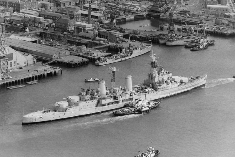 The Royal Navy Town-class light cruiser HMS Belfast under tow from tugboats passes the18th century 104-gun first-rate ship of the line and Admiral Lord Nelson's flagship HMS Victory on her last voyage from Portsmouth Dockyard to her new berth in London as a floating museum on 2 September 1971 in Portsmouth, United Kingdom. (Photo by Keystone/Hulton Archive/Getty Images).