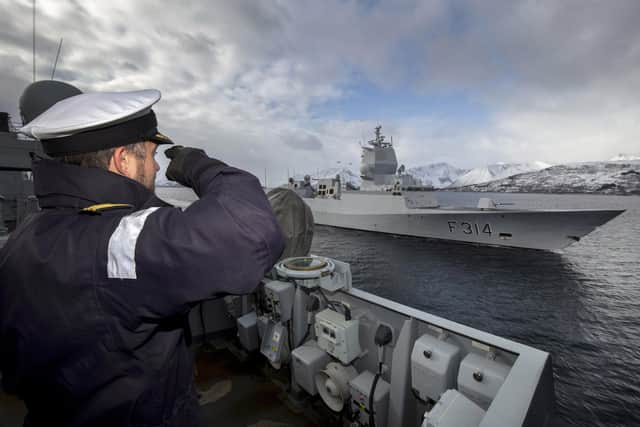 HMS Lancaster's Commanding Officer Cdr Will Blackett salutes as his ship parts company with HNoMS Thor Heyerdahl. Picture: Royal Navy