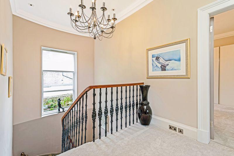 An ornate staircase leads to the first floor, with a rear facing window providing excellent natural light.