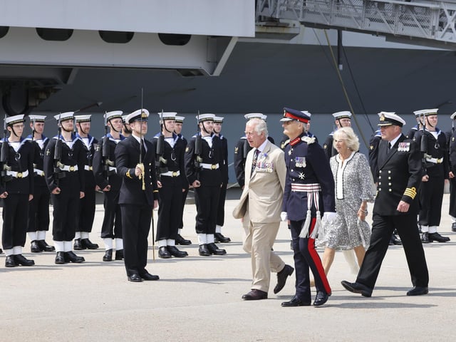 HM Lord-Lieutenant for Hampshire, Nigel Atkinson Esq, welcomes HRH The Prince of Wales and The Duchess of Cornwall to HMS Queen Elizabeth, along with Naval Base commander Captain John Voyce when HMS Queen Elizabeth hosted a unique ‘garden party’ in her hangar for the heroes of Falklands.