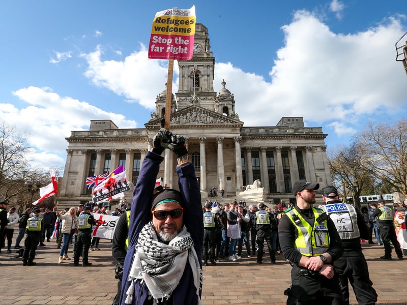 A counter-protestor holds up a sign saying refugees welcome. Picture: Chris Moorhouse (150325-088)