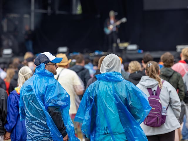 Watching the Tors on stage despite the downpour. Picture: Mike Cooter (240824)
