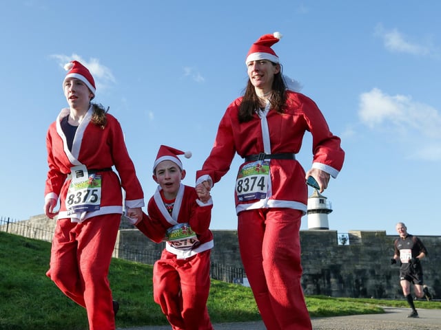 A team of Santas head for the finish line hand in hand.  Picture: Chris  Moorhouse (221224-88)