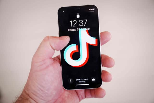 A hand holding a smartphone with the TikTok app on the screen. Photo by BO AMSTRUP/Ritzau Scanpix/AFP via Getty Images