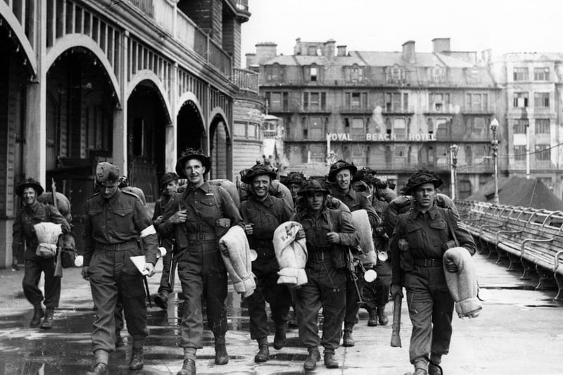 Soldiers walk along South Parade Pier to embark for Normandy.