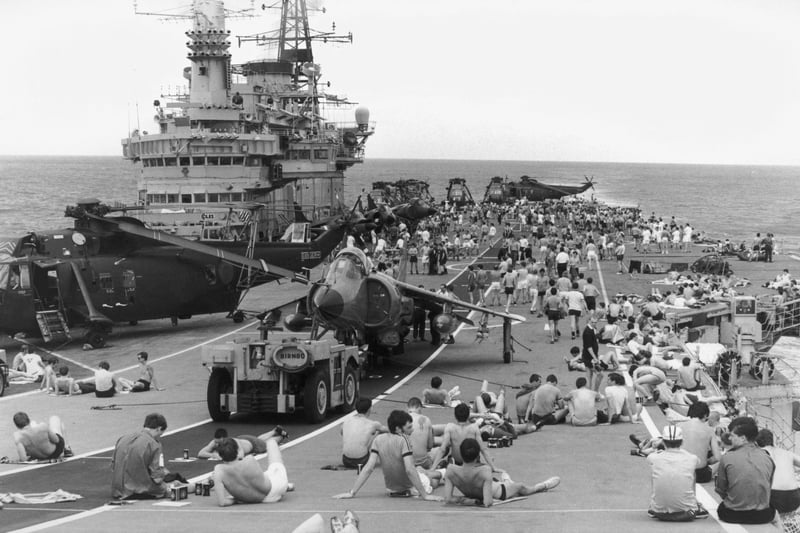 Staff on board HMS Hermes sunbathing on the flight deck as the naval task force heads for the Falkland Islands following the Argentinian invastion, April 1982.