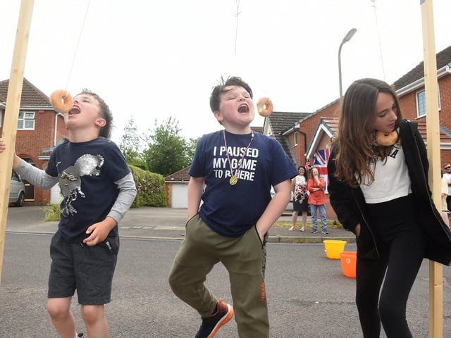 From left Bruno Rawlinson, six, Sam Hulks, 10, and Eva Rawlinson, 12, during the doughnut-eating challenge in Heritage Gardens, Portchester (040622-9343)