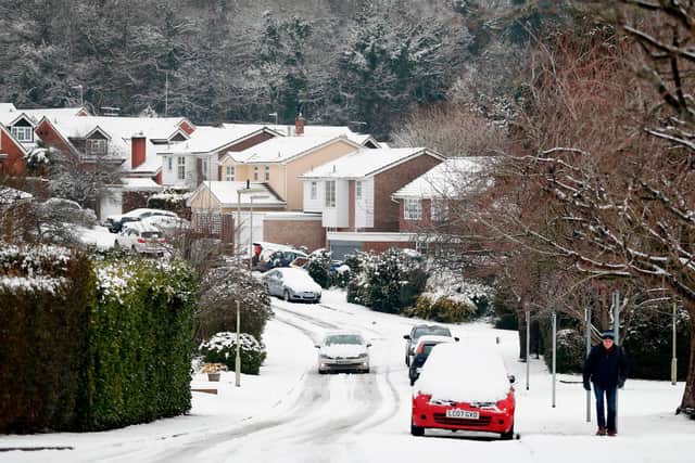 A car drives along a snow-covered residential road in Hartley Wintney, in Hampshire. Picture: ADRIAN DENNIS/AFP via Getty Images