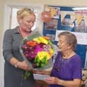 Peggy being presented with flowers for he birthday
