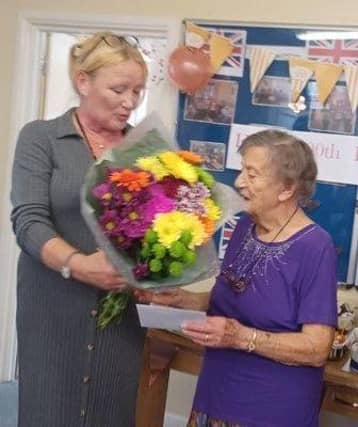 Peggy being presented with flowers for he birthday