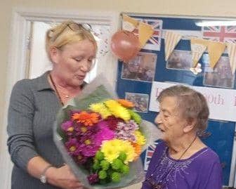 Peggy being presented with flowers for he birthday