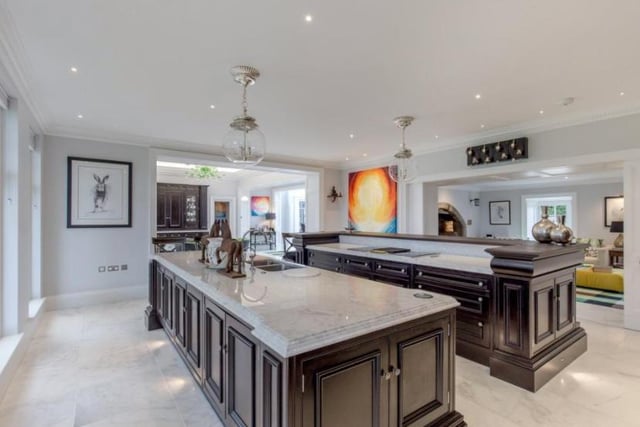 The modern kitchen is described as “the heart of the house”. It was designed by Clive Christian and boasts two island units with white marble work surfaces and Wolf induction hobs.