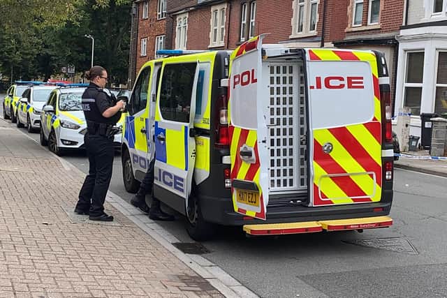 A police officer stands by a police van in Alexandra Road where a suspect had been detained following a robbery. Photo: Tom Cotterill