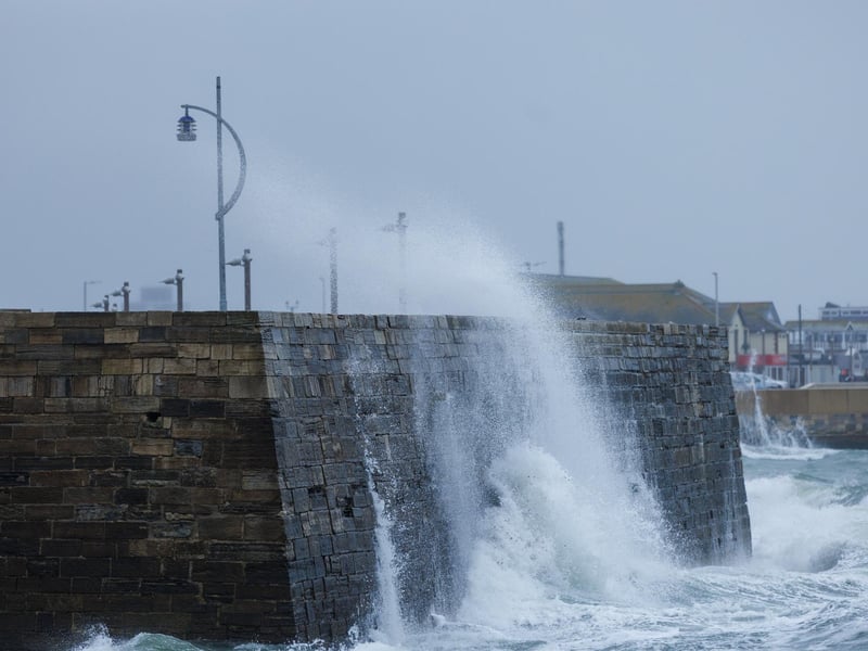 A moody sea crashed waves high onto footpaths as passer-by's did their best to get out the way