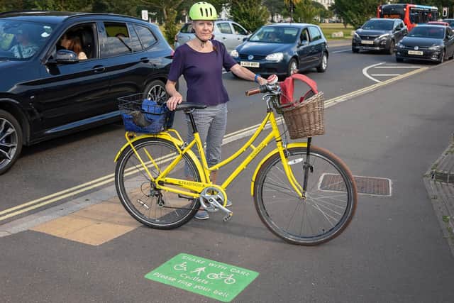 Pat Huxtable (67) next to the tiny sign which shows that the pavement is to be shared by pedestrians and cyclists. Picture: Mike Cooter (080921)