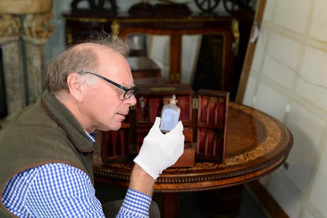 Charles Wallrock inspects one of the bottles in the medicine cabinet that belonged to Sir William Beatty, Nelson's surgeon at Trafalgar.