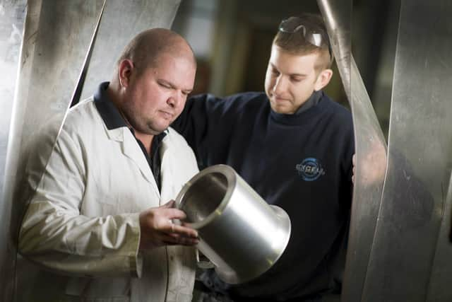 CAPTION: Workers at Excell Metal Spinning in Portsmouth 