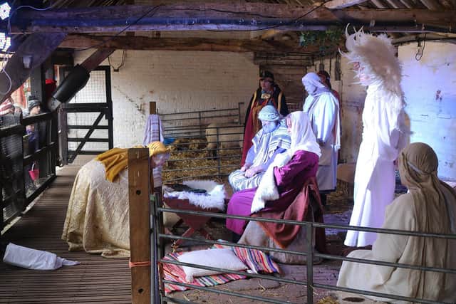 One of the wise men lays their gift at the foot of the manger