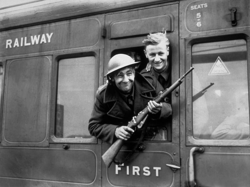 1940:  Troops continue to arrive home in their thousands following the rescue of the British Expeditionary Forces at Dunkirk. This member of the BEF has brought a German rifle home as a souvenir.  (Photo by Parker/Fox Photos/Getty Images)