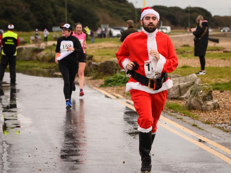 A fully suited Santa approaches the finish at the Christmas Pud 5k, Stokes Bay, Gosport