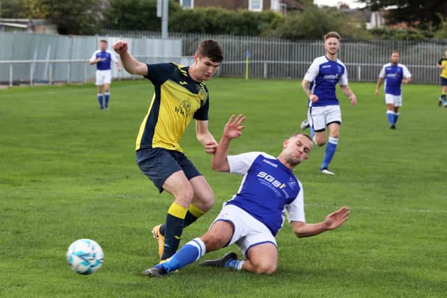 Lewis Crook slides in to tackle Dan Penfold.

Photograph by Sam Stephenson