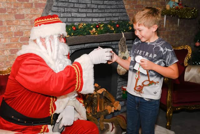Pictured is: Rees Chaplin, 9 receives his gift from Father Christmas.Picture: Keith Woodland (191121-22)