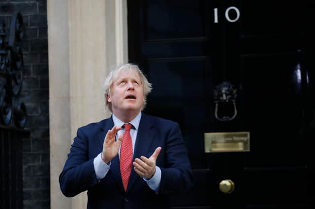 Britain's Prime Minister Boris Johnson participates in a national clap for carers to show thanks for the work of Britain's NHS (National Health Service) workers and other frontline medical staff around the country as they battle with the novel coronavirus pandemic, outside 10 Downing Street (Photo by Tolga AKMEN / AFP) (Photo by TOLGA AKMEN/AFP via Getty Images)