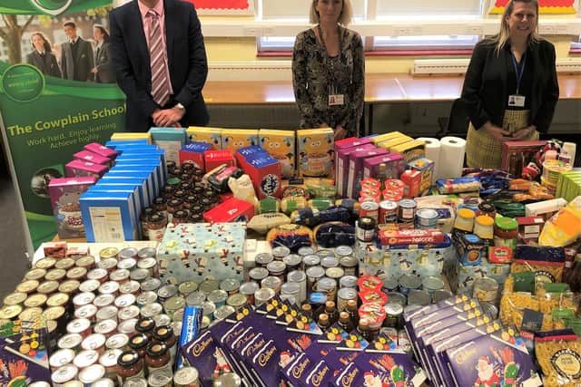 (right to left) The Cowplain School headteacher, Ian Gates, with learning support assistant Adele Lovett and assistant headteacher Lindsey Everritt, alongside the hundreds of items donated to support families in need this Christmas.