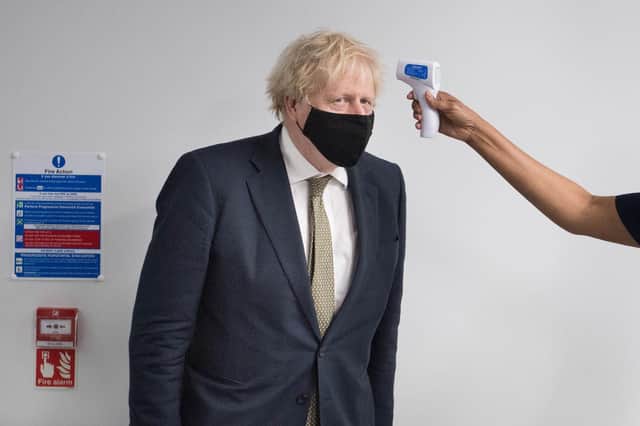 Prime Minister Boris Johnson has his temperature taken during a visit to view the vaccination programme at Chase Farm Hospital in north London. Picture: Stefan Rousseau/PA Wire