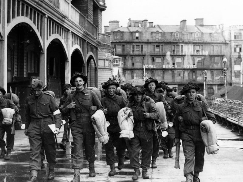Soldiers walk along South Parade Pier to embark for Normandy.