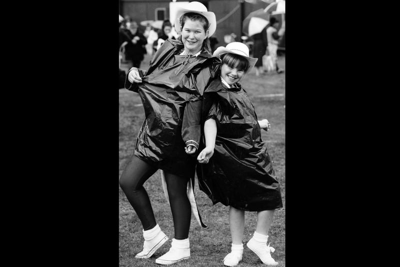 Lorraine Tite (16) and Louse Steels (9), members of the Bognor Babes marching band, keep dry between peformances at the Hayling Carnival, 1993. The News PP5575