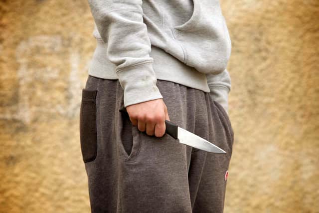 POSED BY MODEL: A youth with a knife