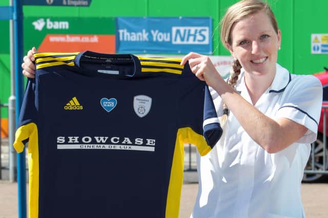 NHS worker Gemma Rix holds up one of the 2020 Hampshire shirts outside University Hospital in Southampton. Picture: Hampshire Cricket