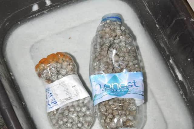 Two plastic bottles with tin foil balls and screws in them shown to the court.