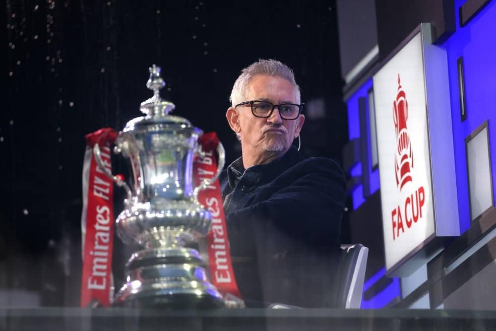 Gary Lineker sits in the BBC Studio next to the FA Cup