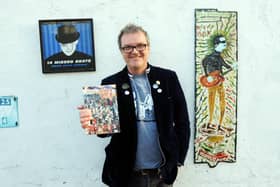 Musician, music fan and writer, Tony Rollinson holding a copy of his book Twenty Missed Beats, with a copy of the accompanying album 14 Missed Beats, and a painting of Tony by Ian 'Sonic' Parmiter. 
Picture by Paul Windsor, 2021.