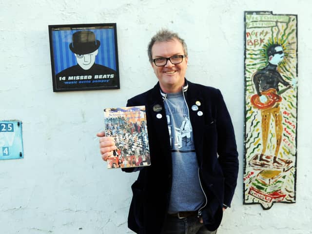 Musician, music fan and writer, Tony Rollinson holding a copy of his book Twenty Missed Beats, with a copy of the accompanying album 14 Missed Beats, and a painting of Tony by Ian 'Sonic' Parmiter. 
Picture by Paul Windsor, 2021.