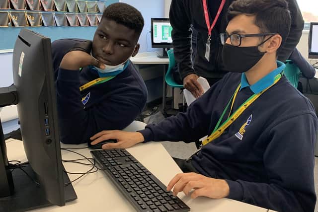 Israk Ali, Senior Systems Engineer, at Lockheed Martin, helping two students from UTC Portsmouth complete the cyber themed challenge