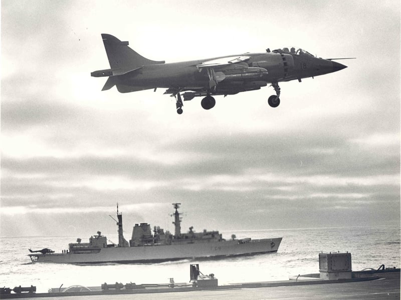 Sea harrier of 800 NAS prepares to land on HMS Hermes with MHS Battleaxe beyond.