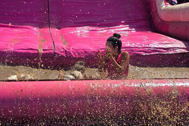 Finish the Pretty Muddy course on the giant inflatable slide and land in the mud pit.