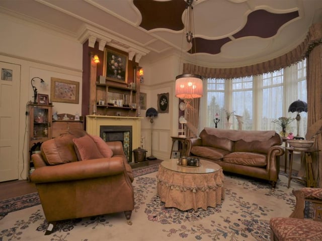 The bow windowed drawing room has a period fireplace, additional window to the side, and some magnificent intact decorative cornicing and mouldings.