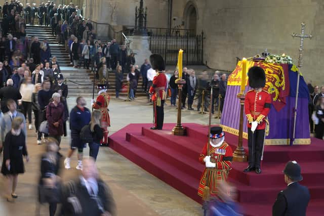 Members of the public file past the coffin of Queen Elizabeth II, draped in the Royal Standard with the Imperial State Crown and the Sovereign's orb and sceptre, lying in state on the catafalque in Westminster Hall, at the Palace of Westminster, London, ahead of her funeral on Monday. Picture date: Friday September 16, 2022.