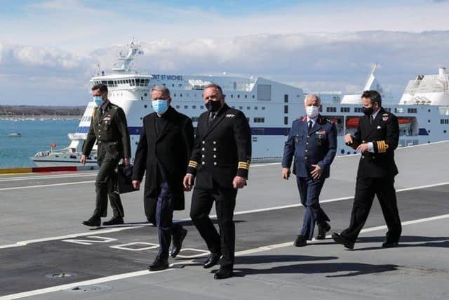 Image of Commander Air, Philip Beacham (right), leads a tour of the flight deck of HMS Prince of Wales in Portsmouth with Turkish defence minister Hulusi Akar (left).
