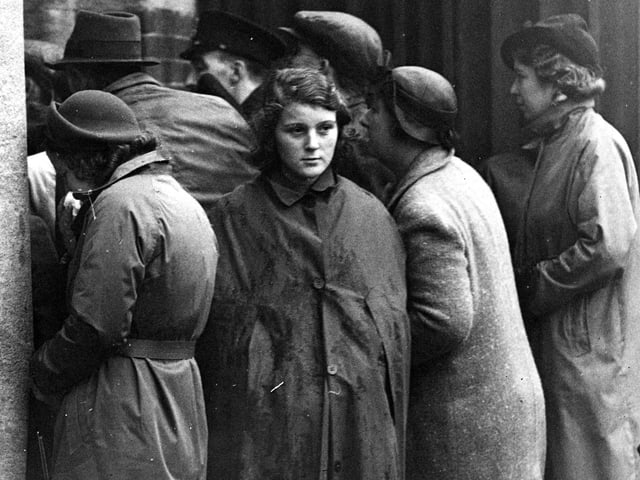 15th October 1939: Anxious relatives read a list of survivors from the HMS 'Royal Oak' posted up at a South Coast Port. The Admiralty states that battleship was sunk by a U-boat. (Photo by E. Phillips/Fox Photos/Getty Images)