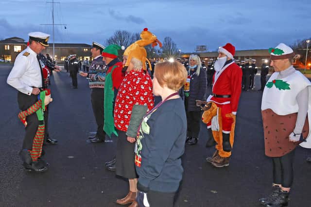 Sailors wearing festive jumpers take part in a charity divisions event on HMS Sultan's parade square