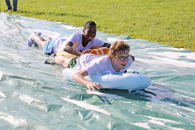 Teenagers enjoy the water slide on the High Tide holiday