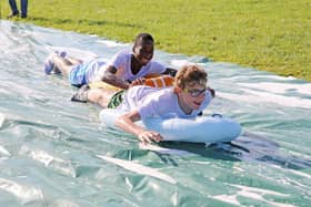 Teenagers enjoy the water slide on the High Tide holiday