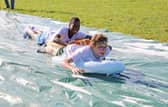 Teenagers enjoy the water slide on the High Tide holiday
