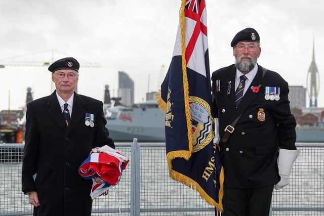 Peter Featherstone Williams (left), veteran and chairman of the Bristol Association, and Dick Shanton, HMS Bristol's standard bearer, receiving the White Ensign that was lowered for the last time after the vessel was officially decommissioned.